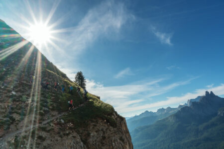 large group of young hikers going up a steep hiking trail with the sun shining&hellip;